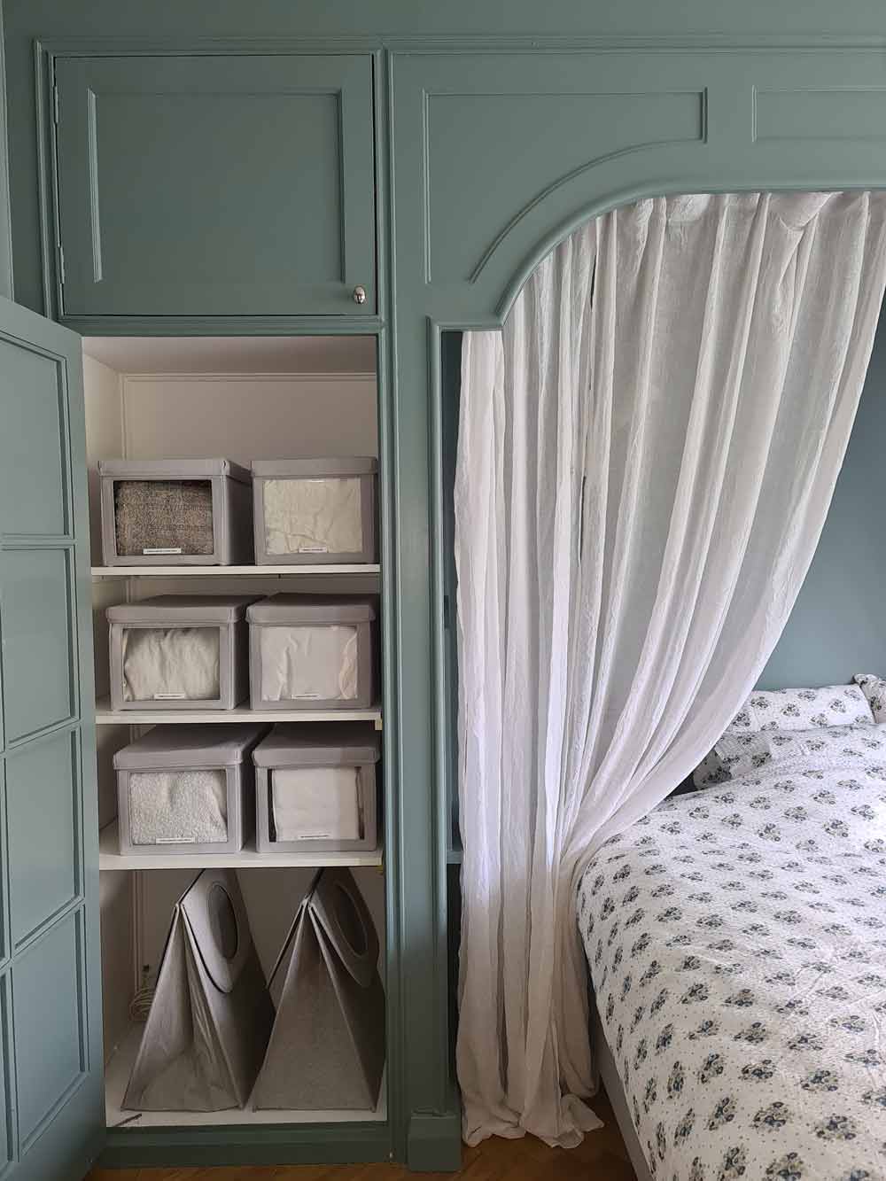 Stilrent sovrum i turkosa färger som har en organiserad garderob.