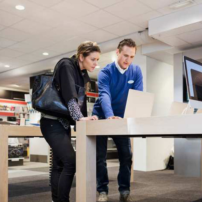 En man och en kvinna kikar på en dator